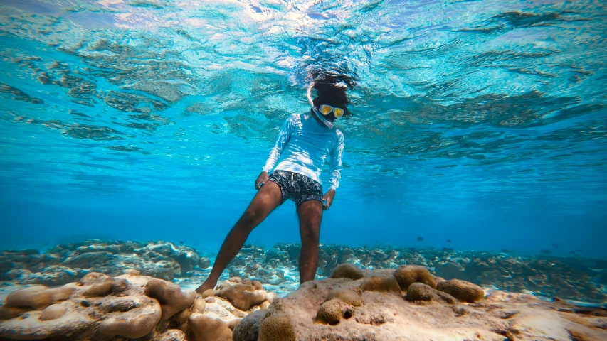 a man standing on a rocky beach under water