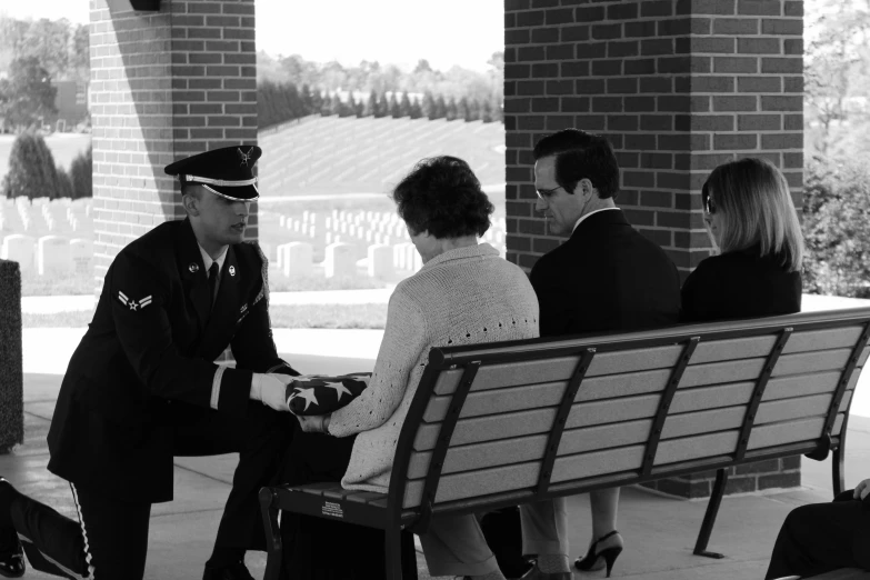 a black and white picture of two people on a bench