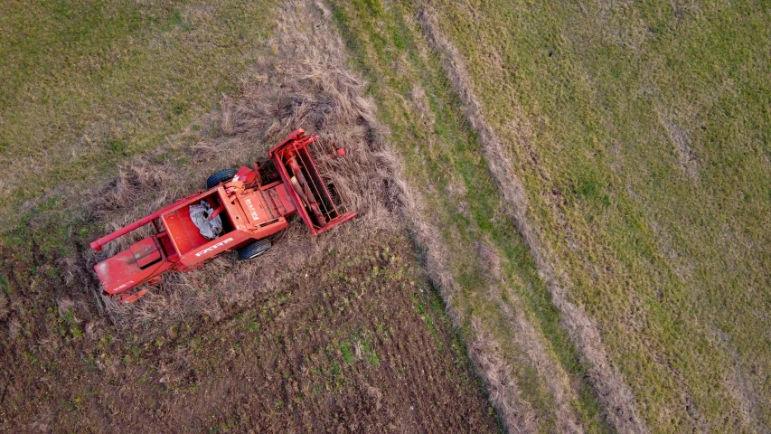an old red tractor plows through a field