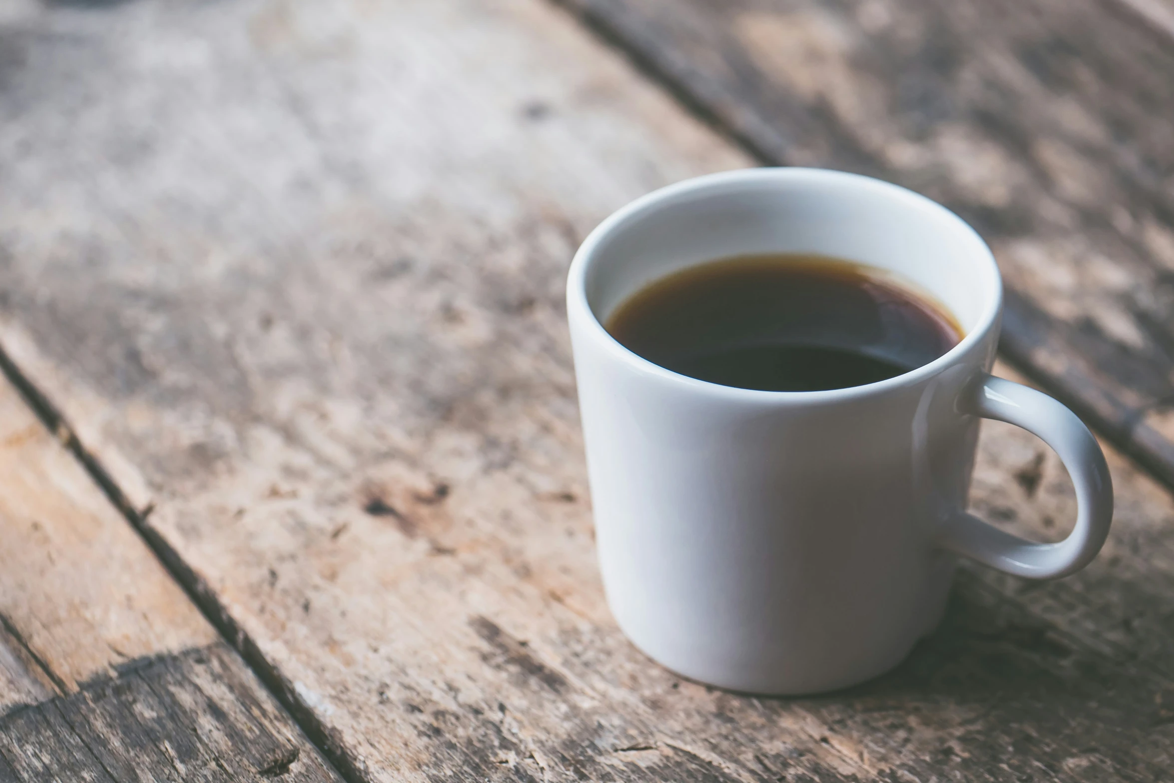 a cup filled with a drink on top of a wooden floor