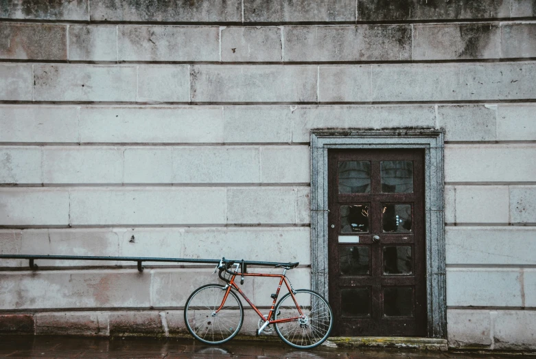 bicycle leaning against the wall and door of a building