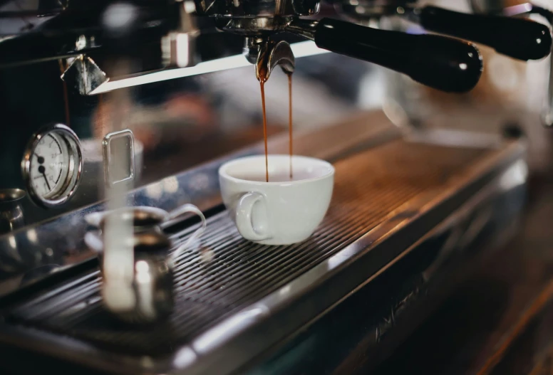 an espresso machine with a cup of coffee running