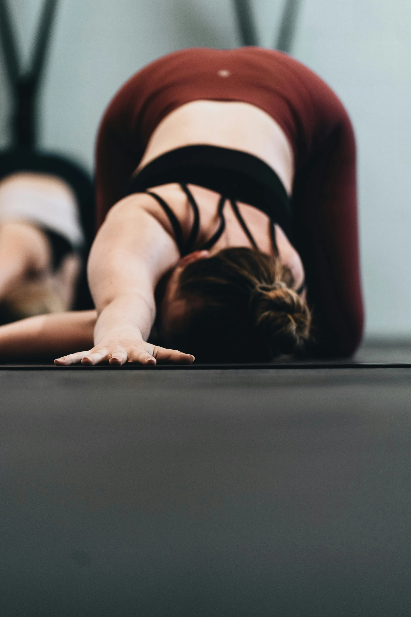 a woman is laying on the ground doing a hand stand