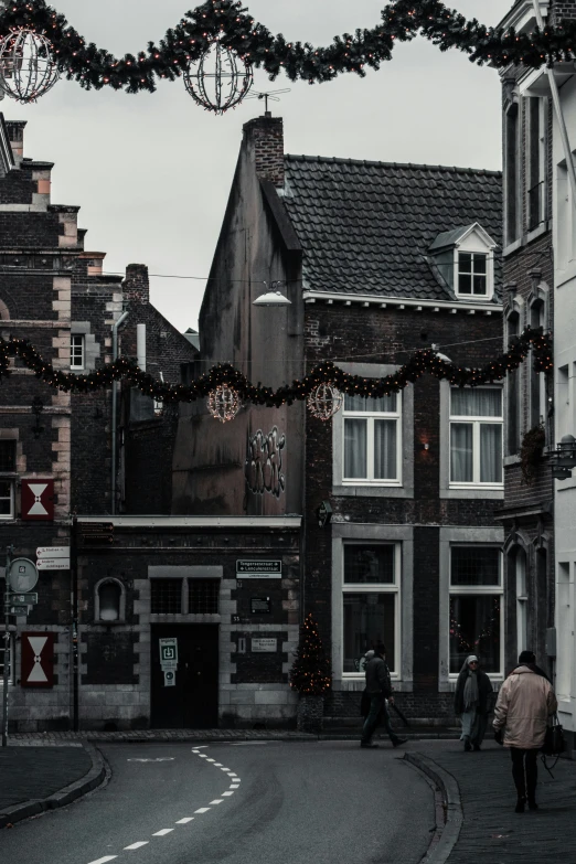 two people walk down an empty street in an old town