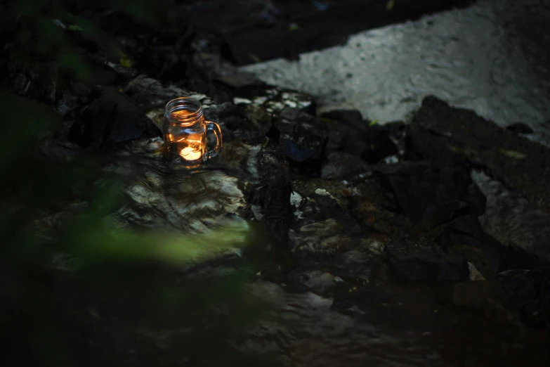 a small lantern sits on the edge of a rock