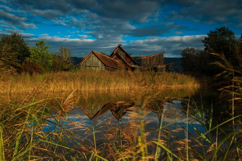 a building on top of a field next to trees and water