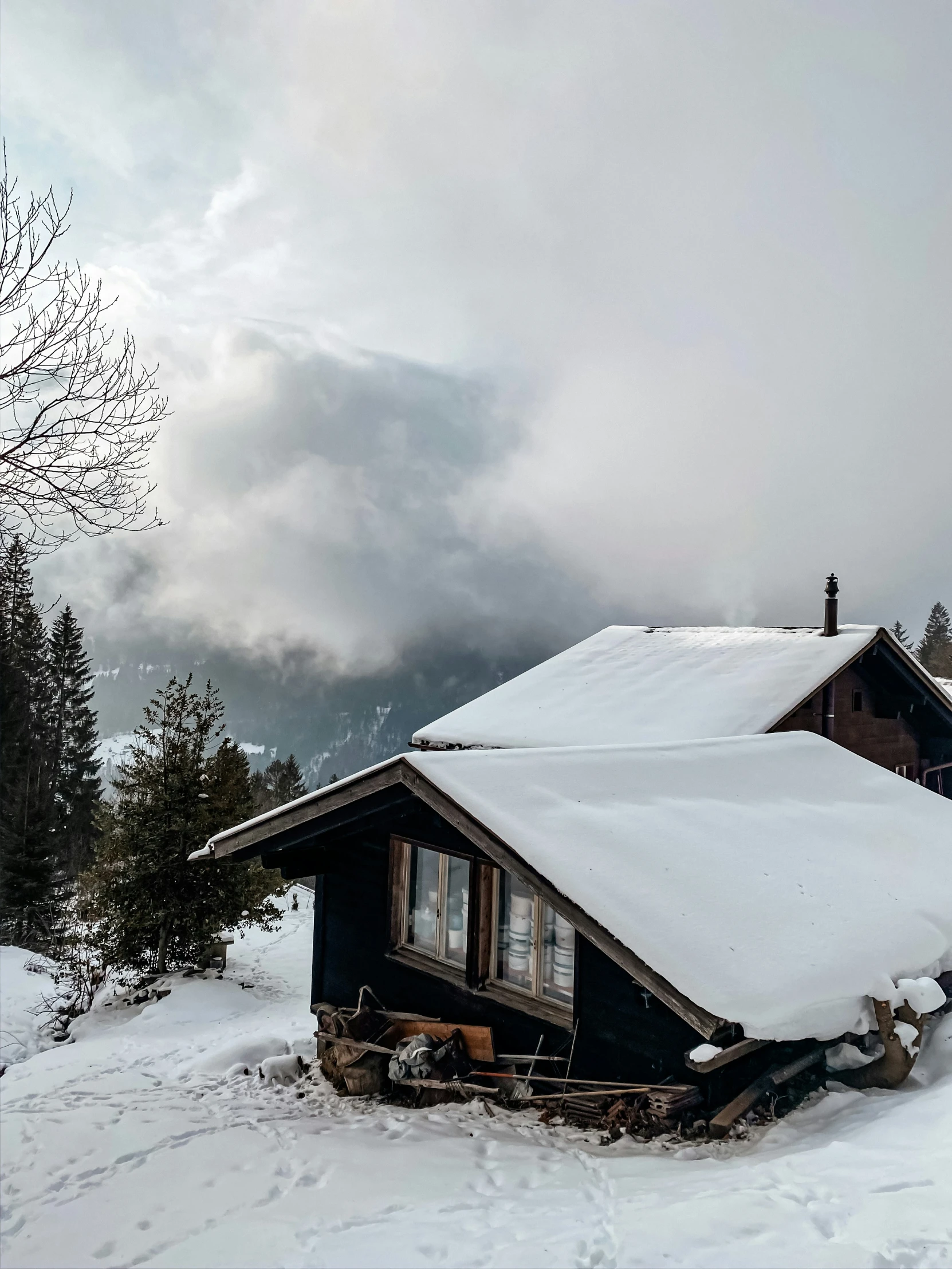 the front of a small cabin with snow on the roof