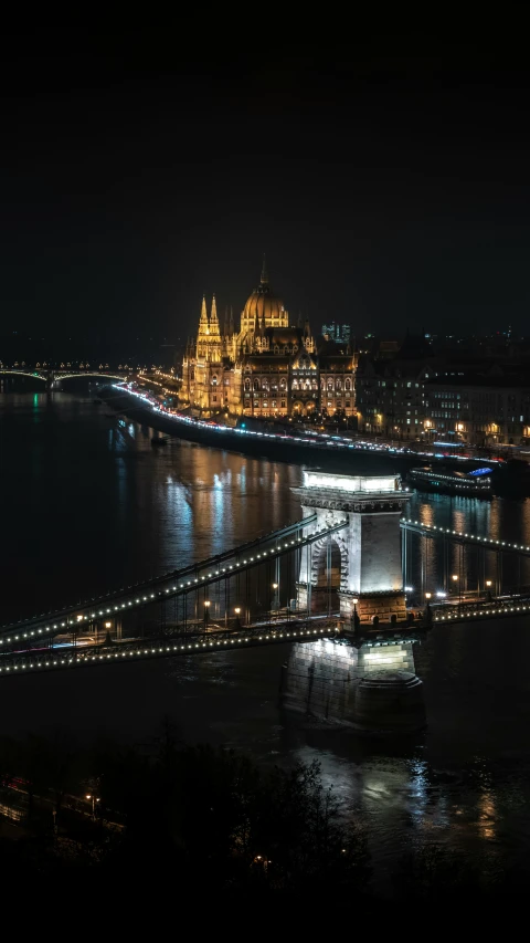 a very long bridge spanning over water with buildings in the background