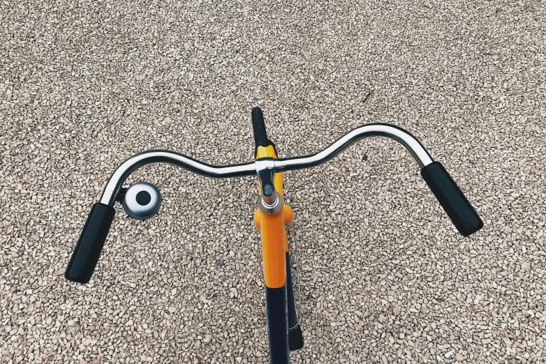 a bike is parked on the sidewalk, with its handle bars bent out