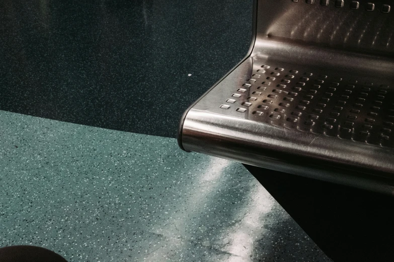 a silver colored metal chair and a green carpet