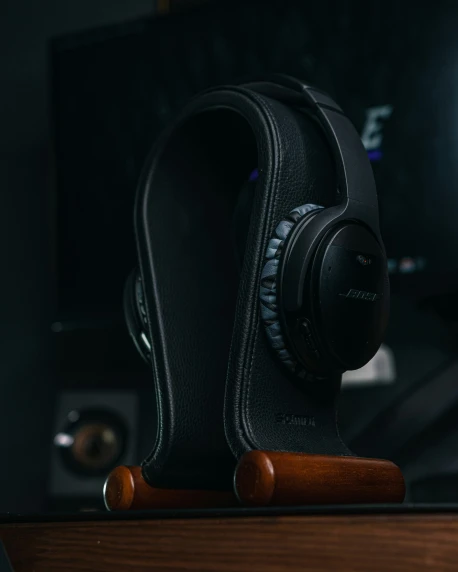 black leather headphones rest atop a desk