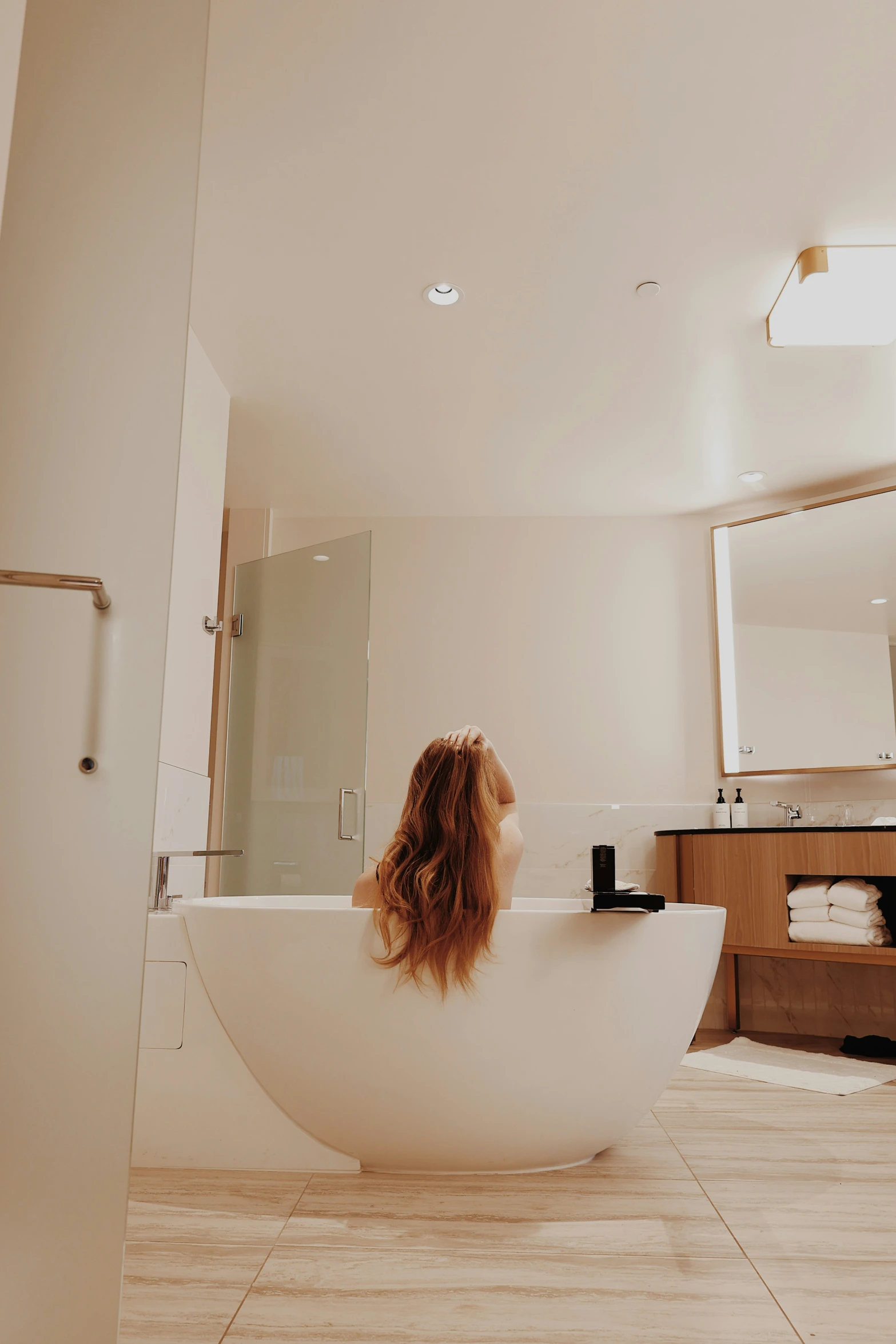 woman sitting in a bathtub looking out at the outside