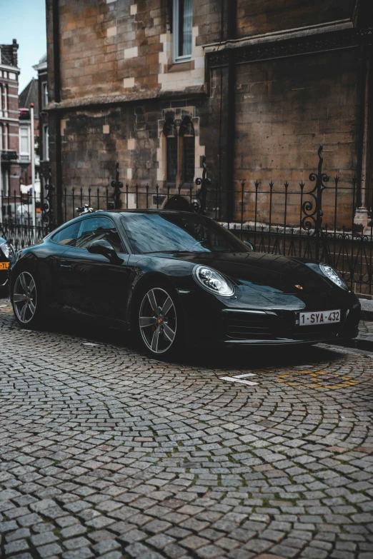 the black sports car sits on the sidewalk