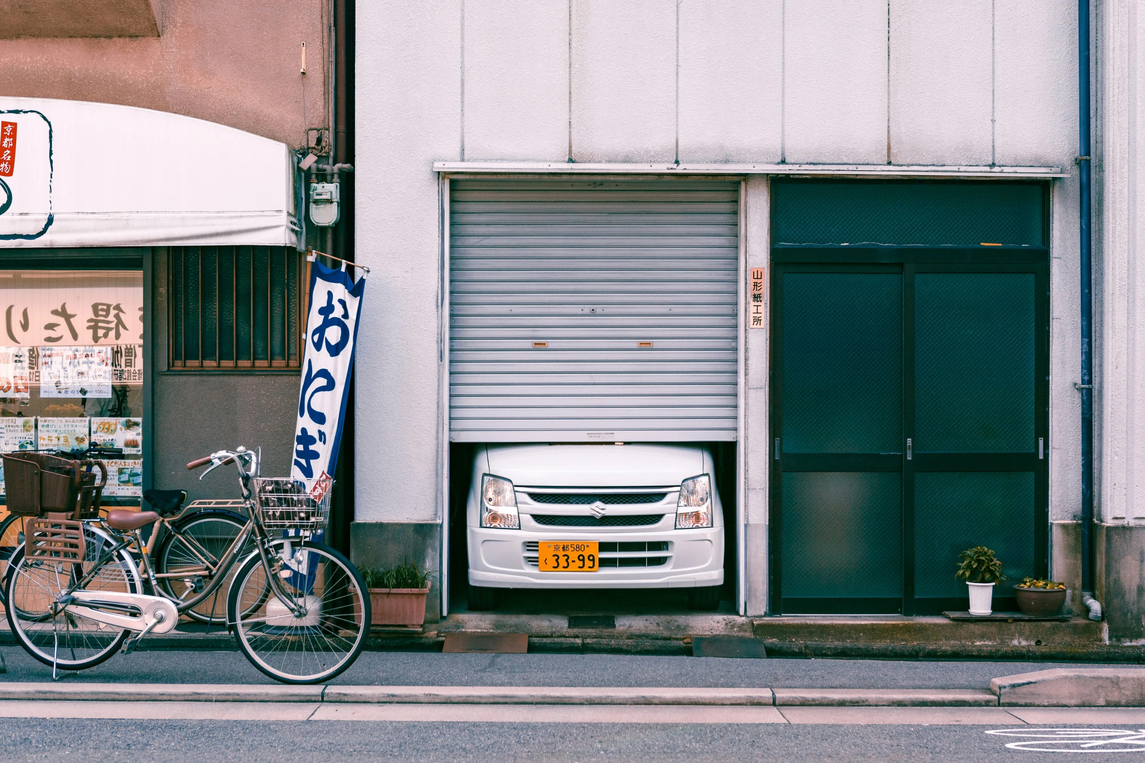 a pair of bikes parked on the side of the street next to an outside shop