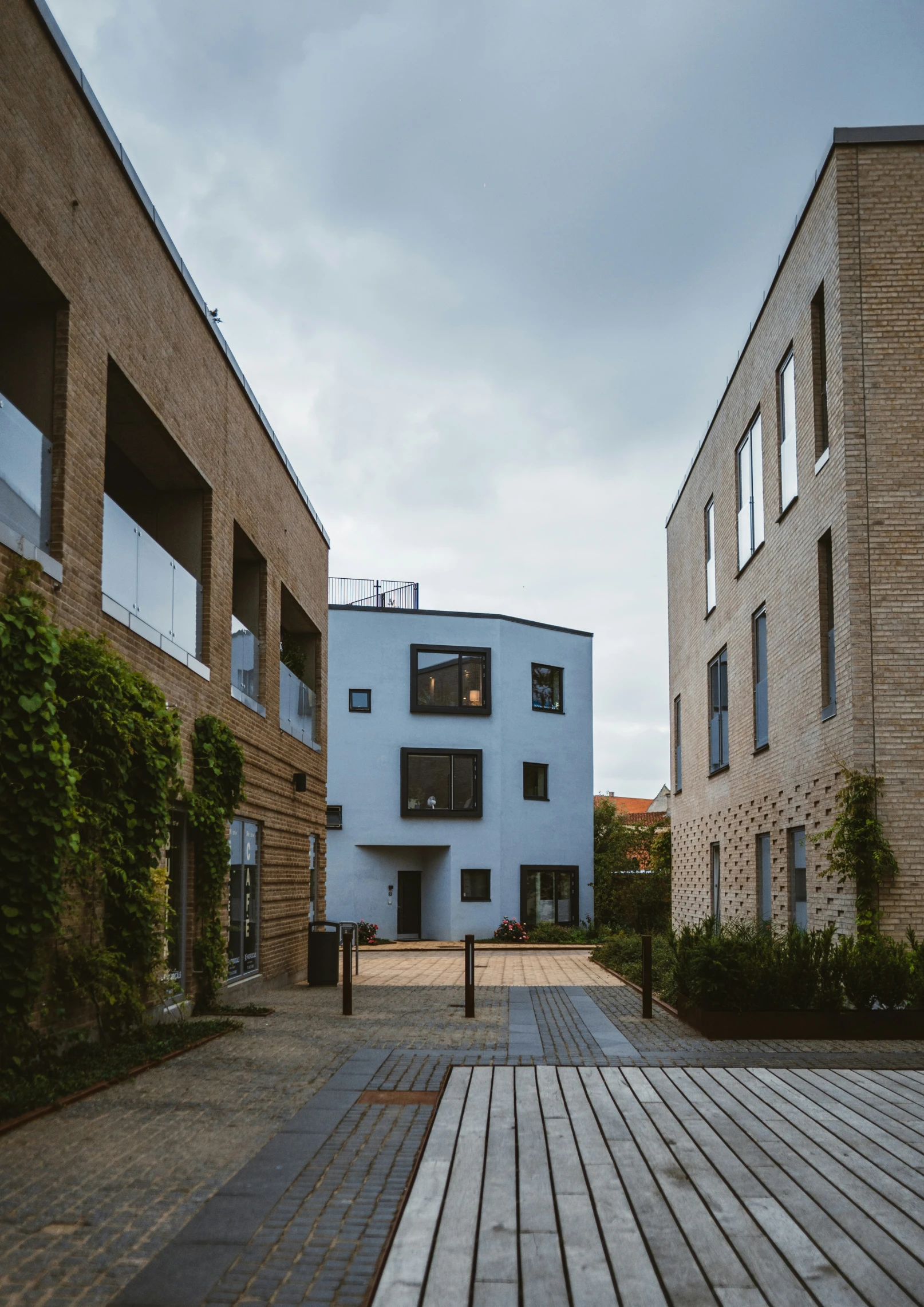 a walkway leads to an outside courtyard that includes trees and potted plants