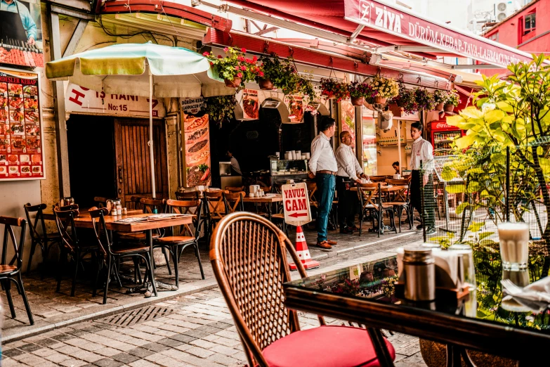 a couple of people standing outside a restaurant next to chairs