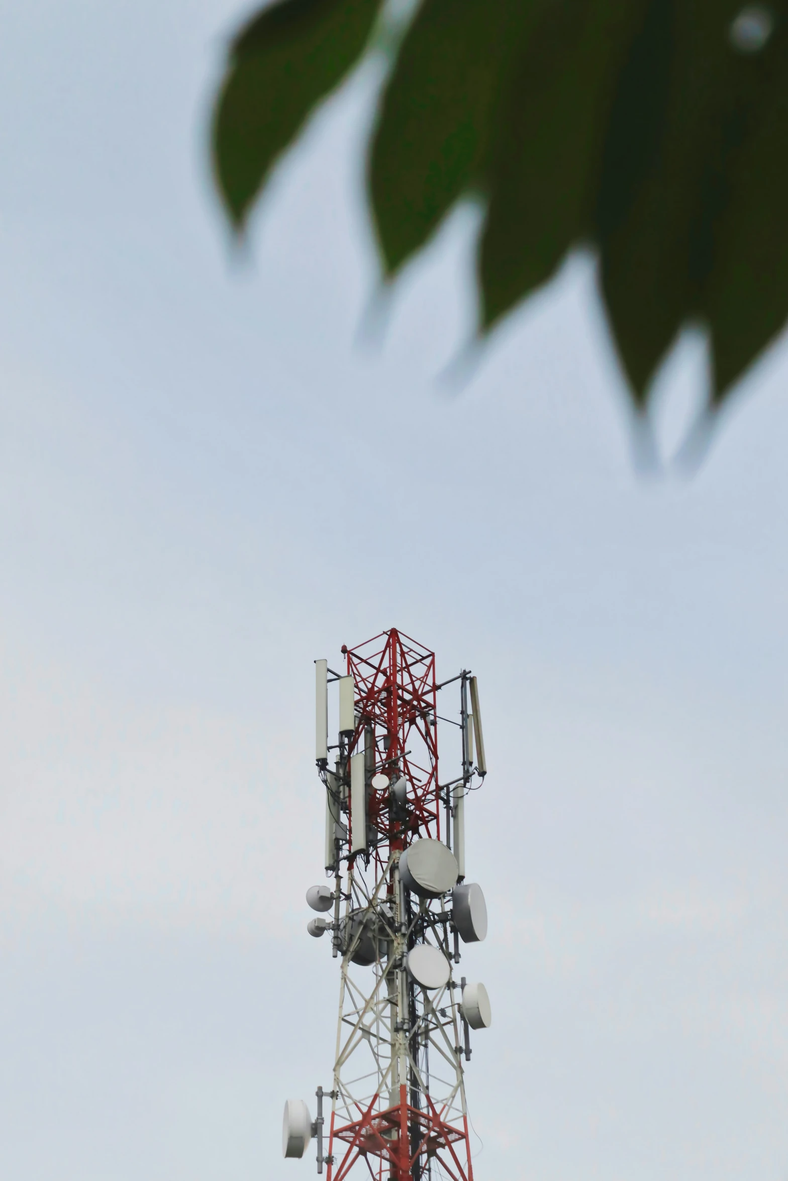 a red and white tower with three cell towers