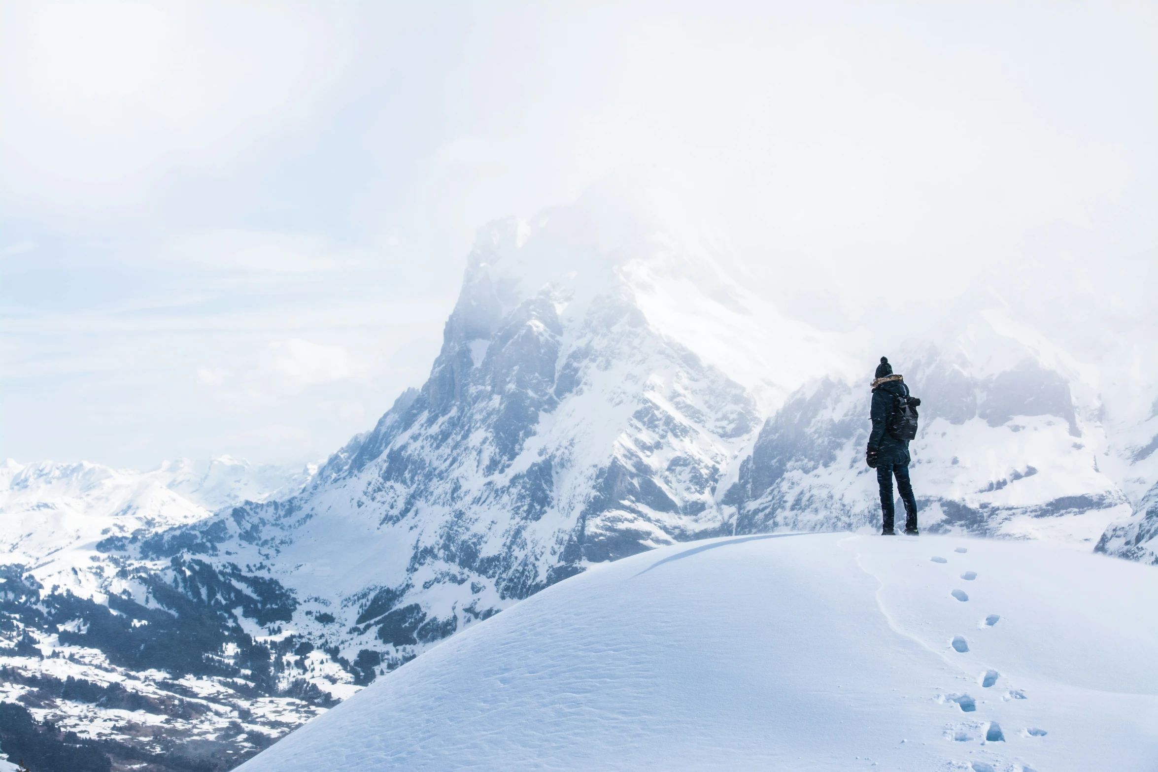 a person is standing on a snowy mountain