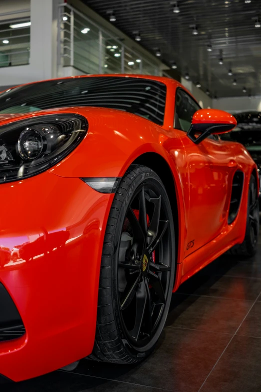 a red sports car parked inside a showroom