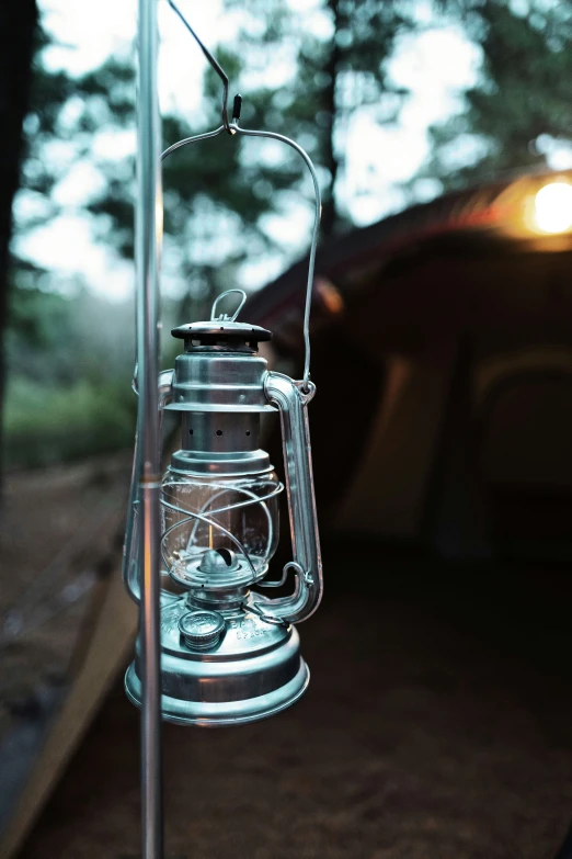 a glass lantern hanging from a pole in the night