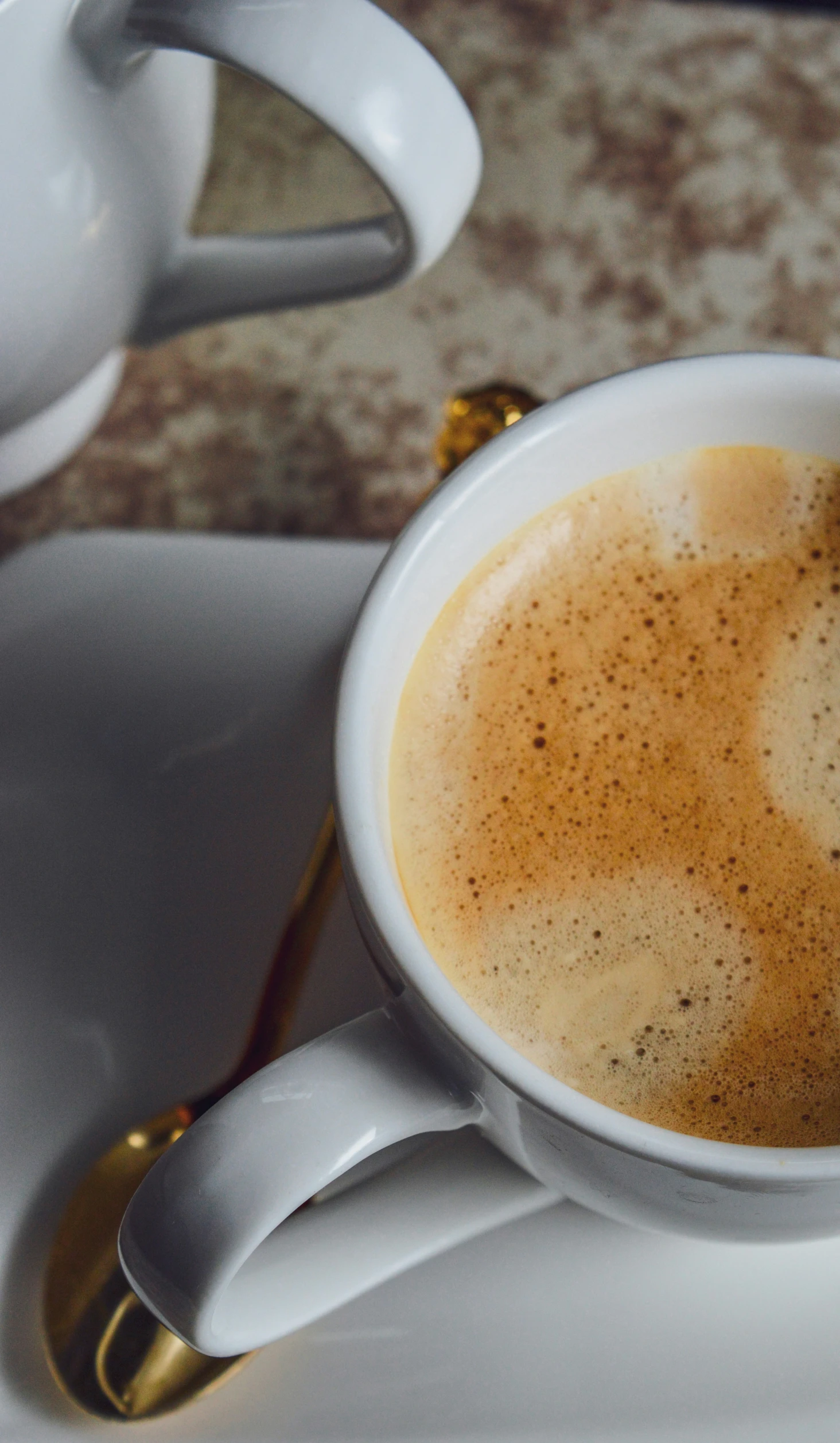 a close up of a cup of coffee with a spoon in it