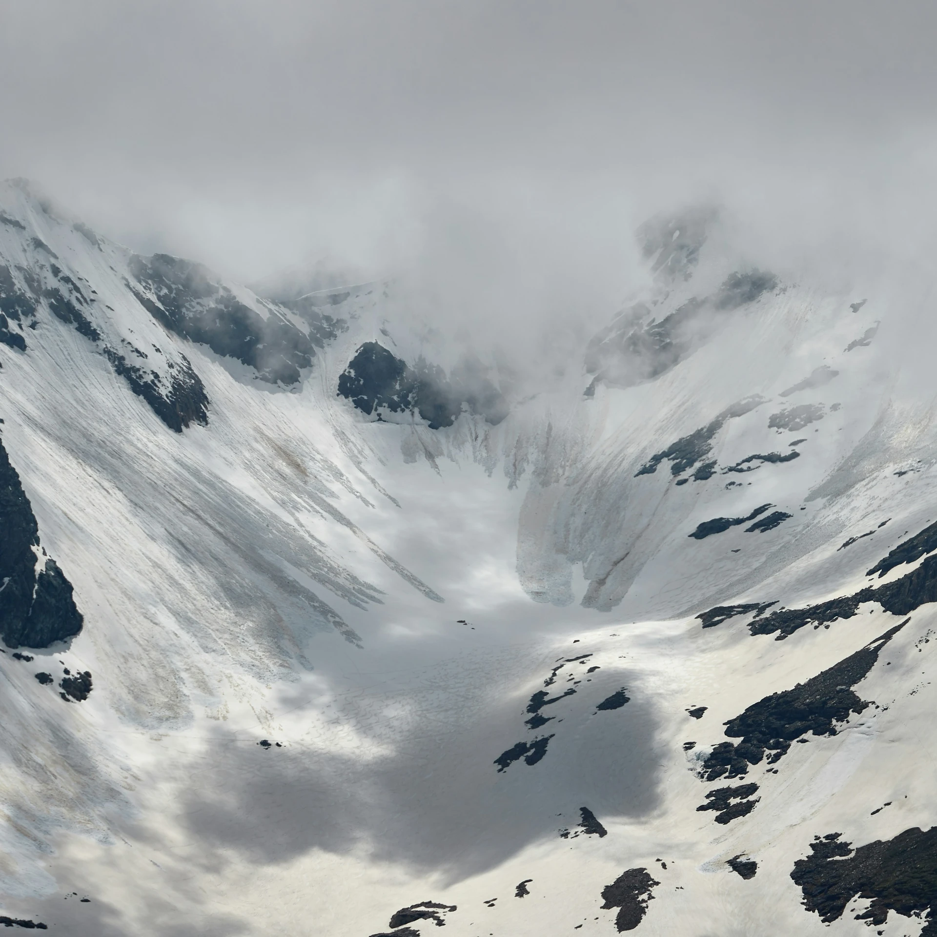 there are snow and clouds on the mountain