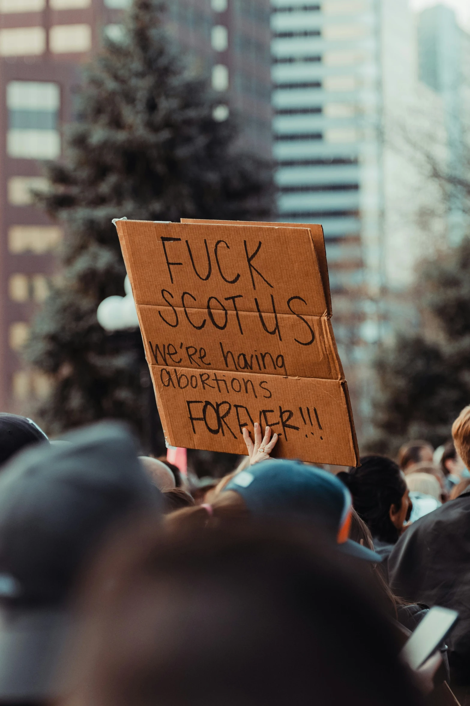 a protest sign with the words luck and success in front of a crowd of people