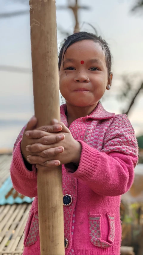 the small girl is holding the pole in her hands