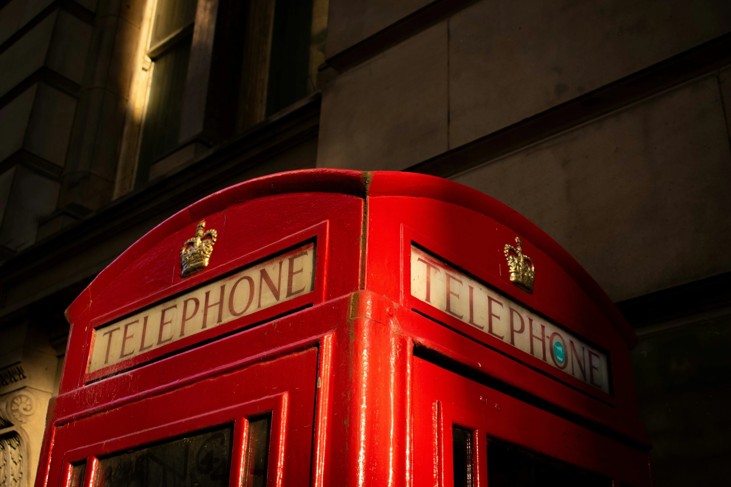 an old fashioned telephone booth stands in front of a building