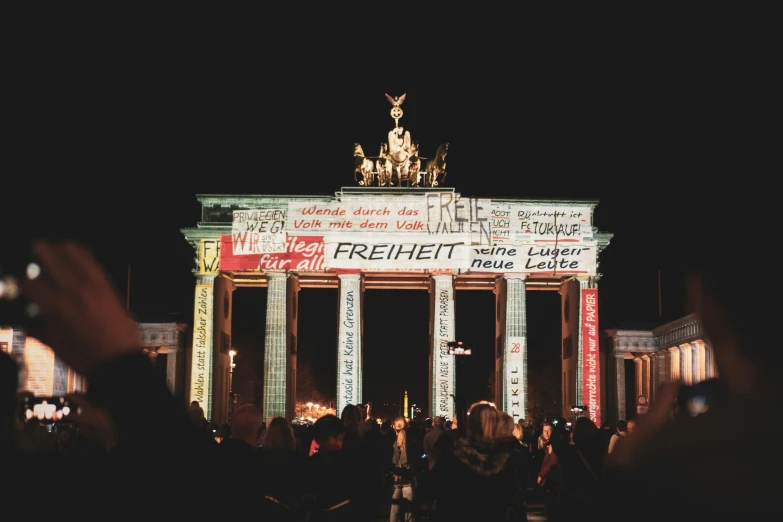 people standing in front of a illuminated arch