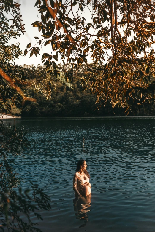 woman standing in water surrounded by trees and water