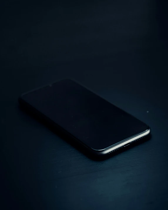 a smartphone is sitting on the surface of this black table