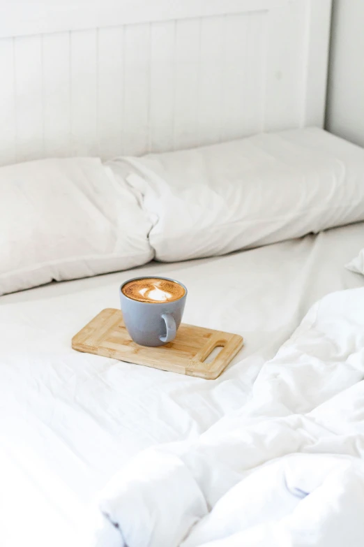 a cup of coffee on top of a wooden tray