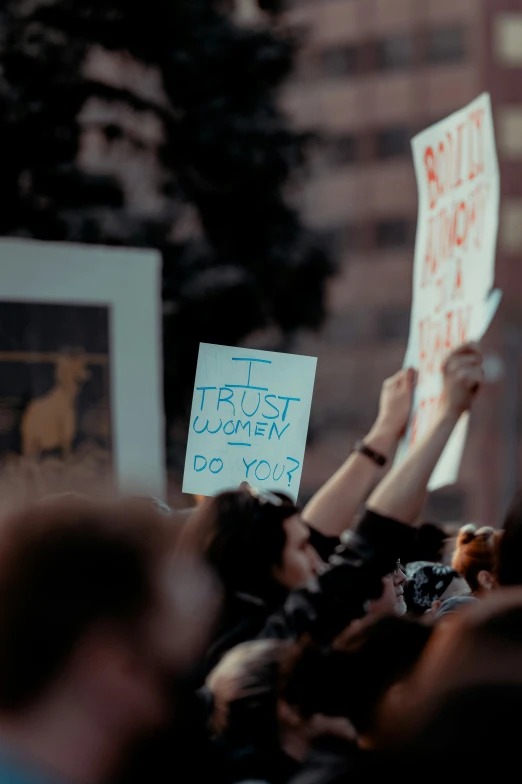 a crowd of people holding up signs in front of a building