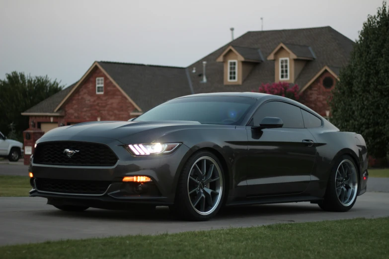 a ford mustang is parked in front of a house