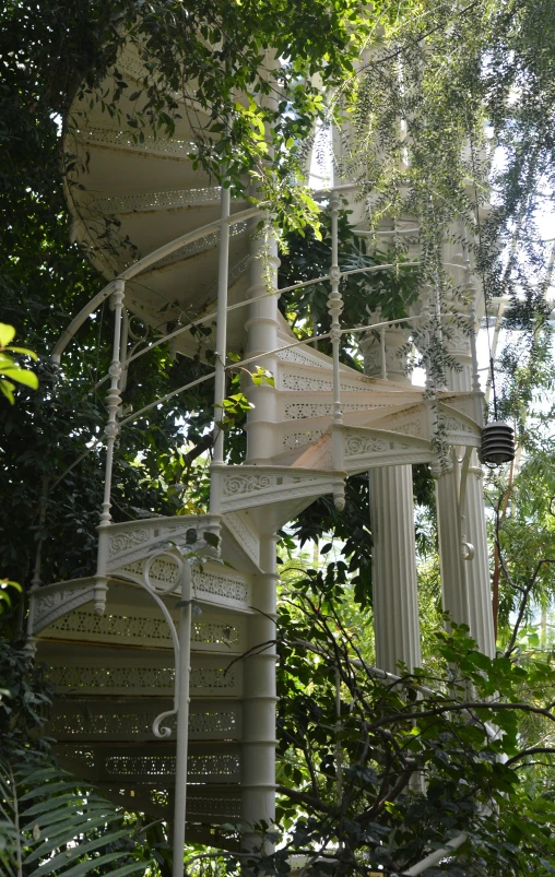 a circular white structure is surrounded by trees