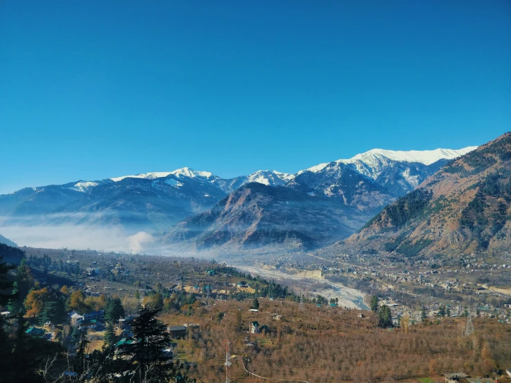 some hills with a few snow capped mountains on the right