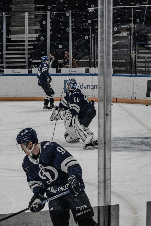 hockey players in uniform playing on an ice rink