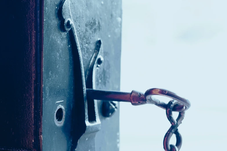 the handle of an old fashioned lock on a black door