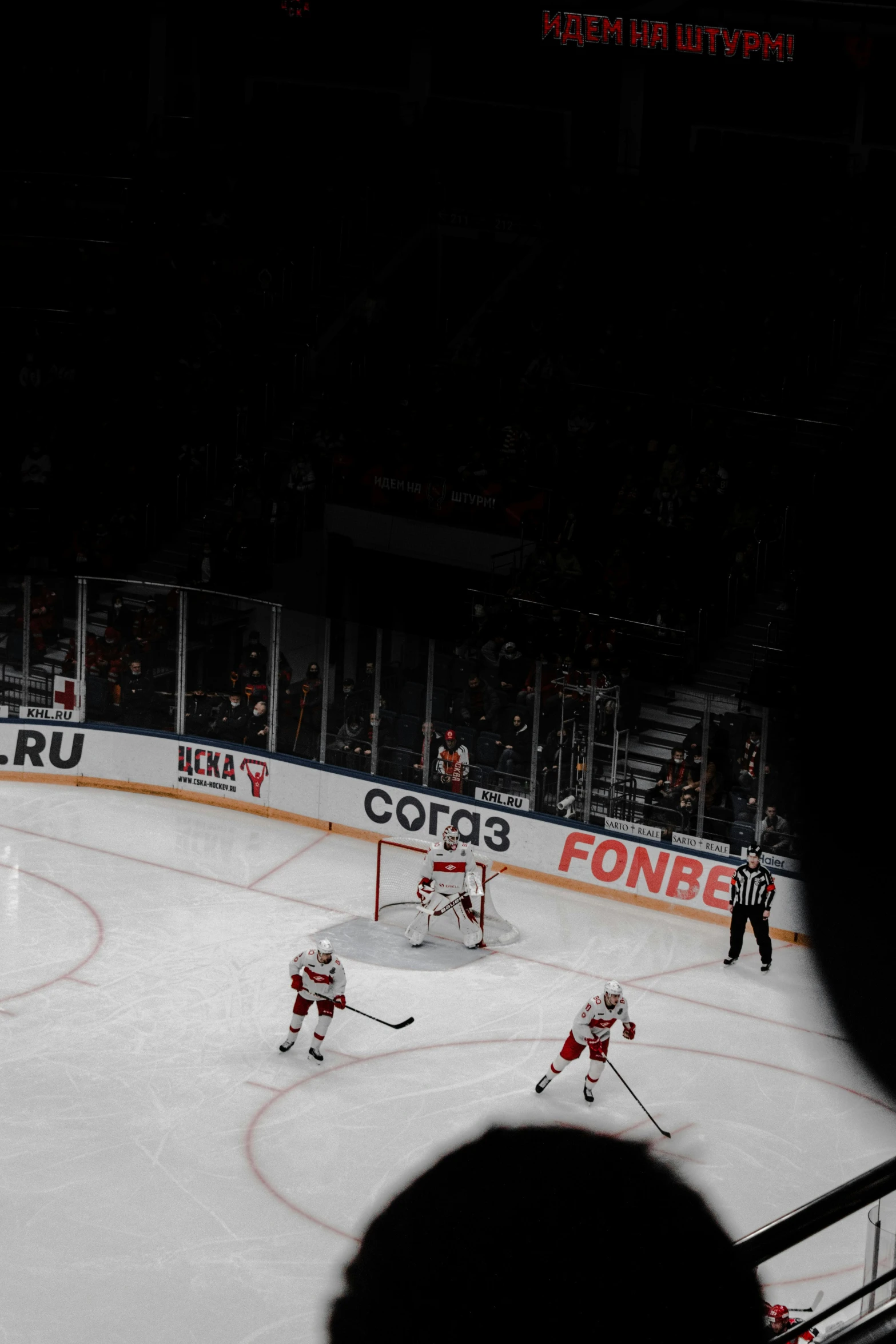 a hockey game in progress at night as the players are going for the puck