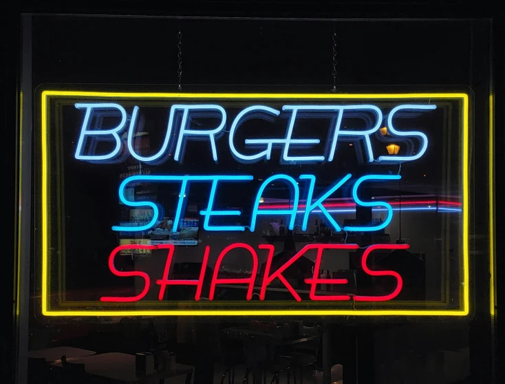 a neon sign has a burgerer's steaks on it