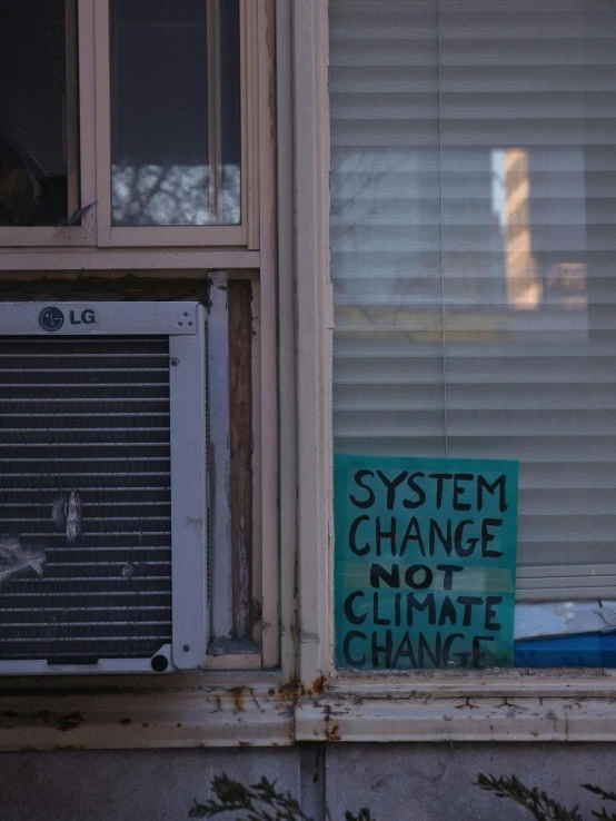 a sign on a windowsill warns people to be climate change