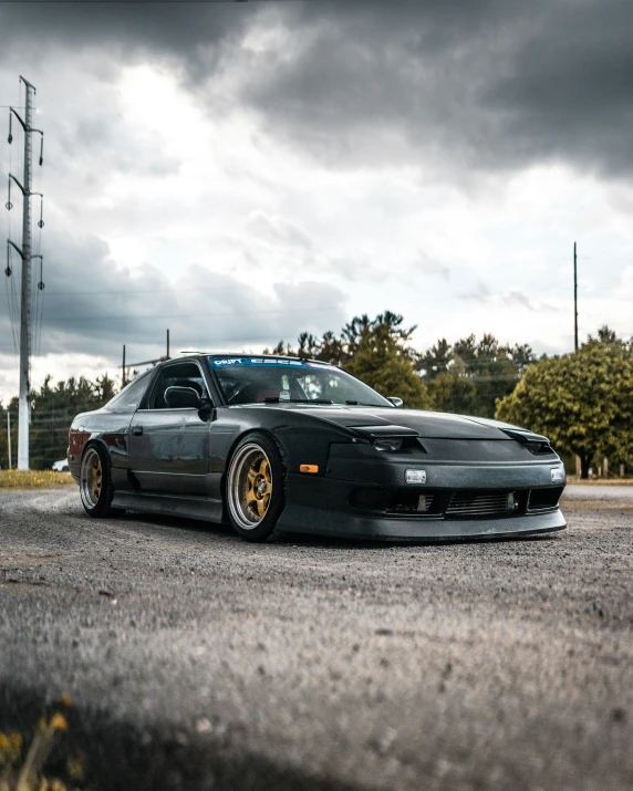 a grey sports car is parked in the middle of an asphalt road