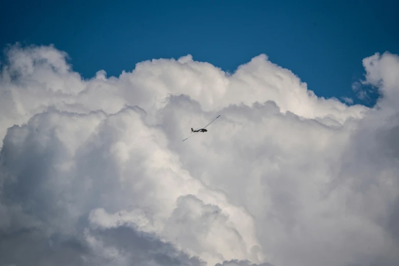 the plane is flying on a cloudy sky