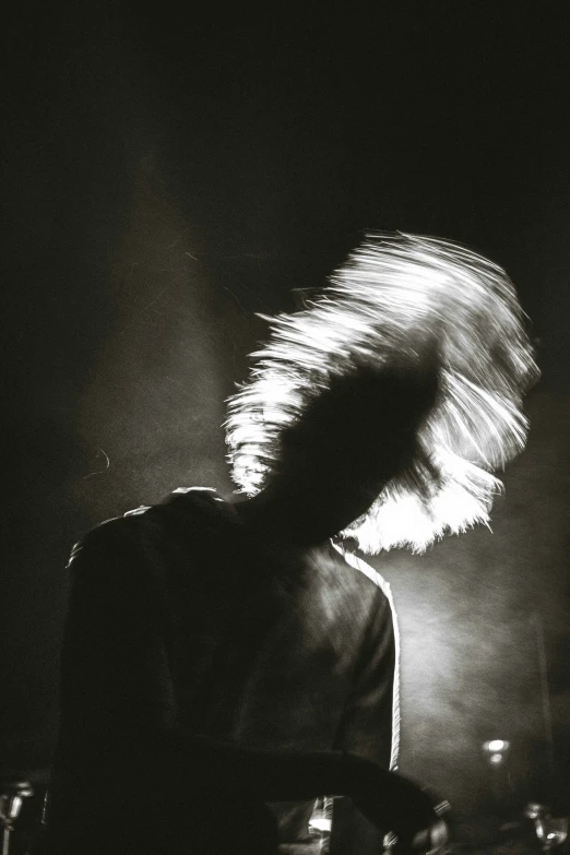 a person holding their hair in front of a microphone