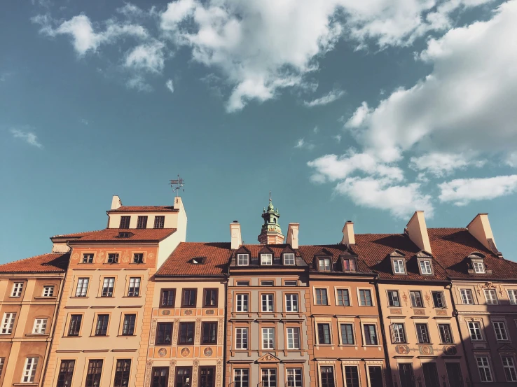 a tall brick building with many windows under a cloudy sky