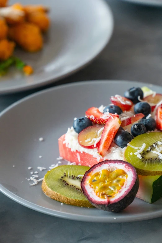 there is a bowl full of food, and one of the plates has berries on it