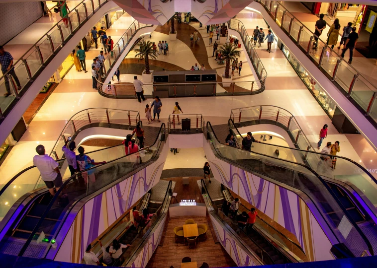 an aerial view of a shopping mall as people walk down the escalator