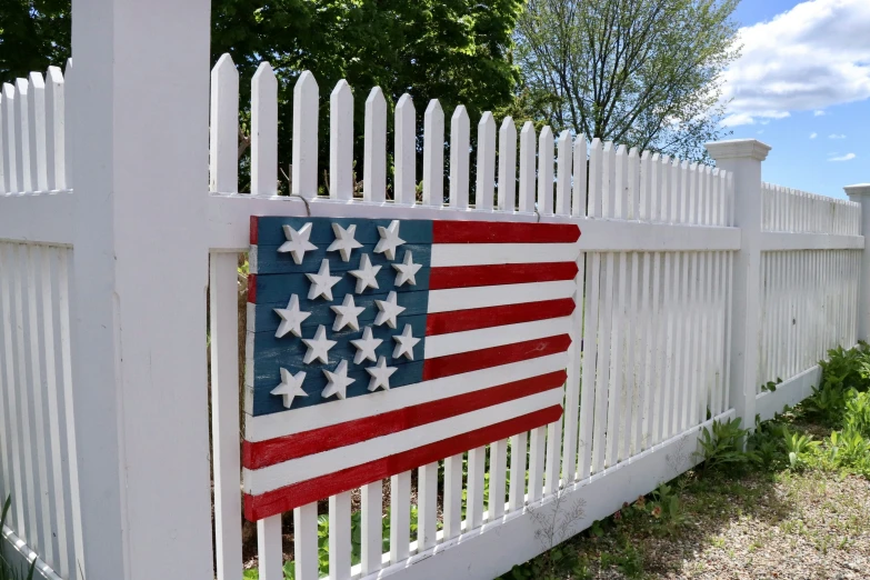 the american flag painted on a white picket fence