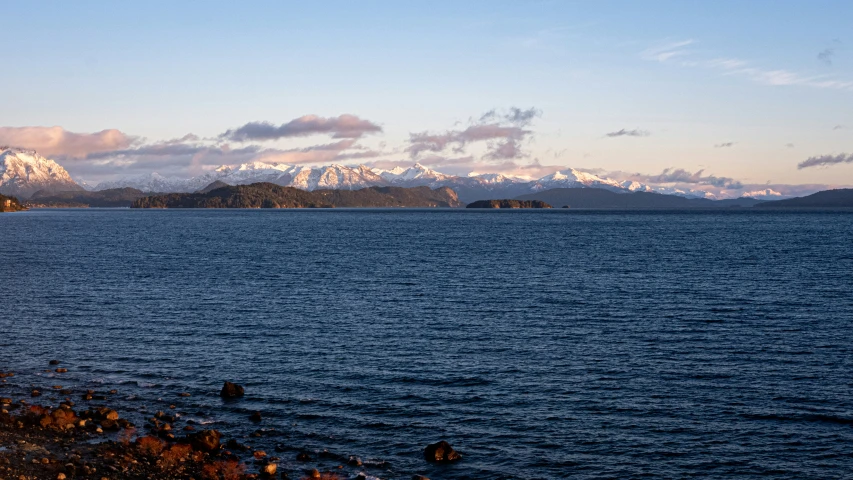 snowy mountains are in the distance of the water